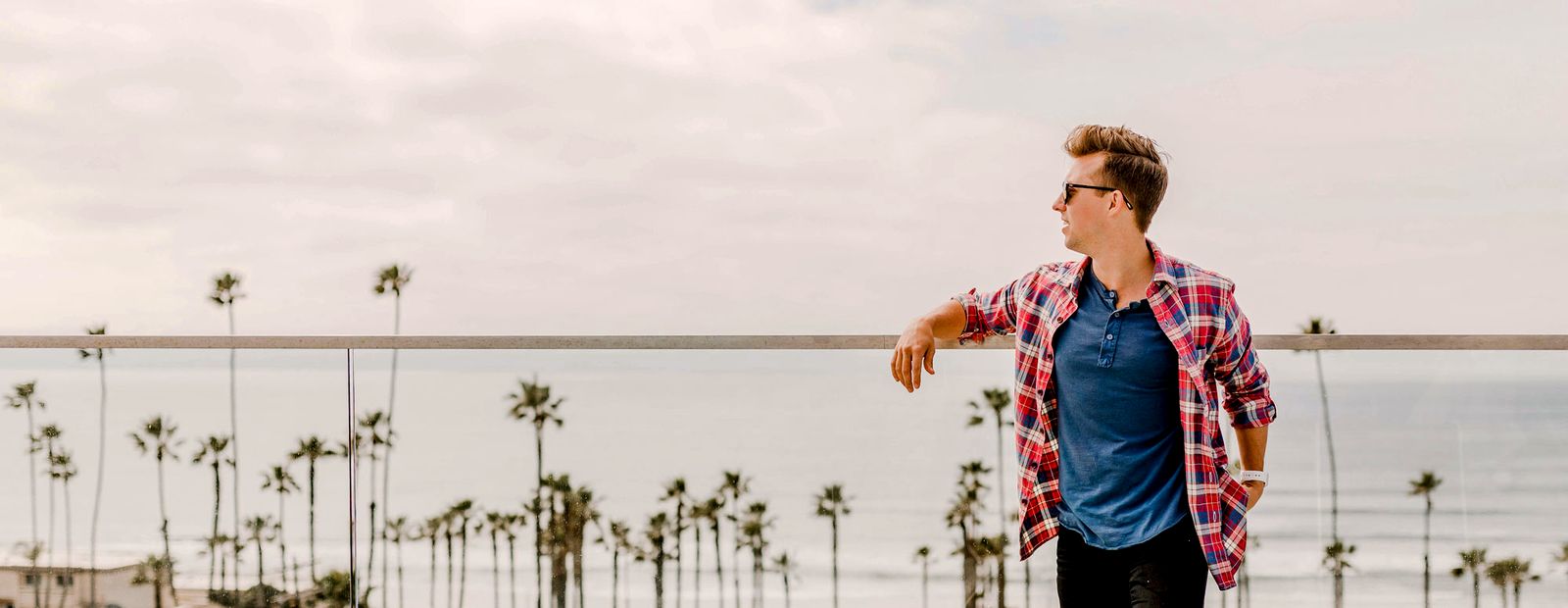 A traveler looking out over a palm-lined coastline